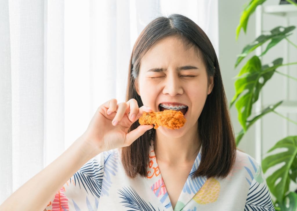Woman experiencing tooth pain when eating food.