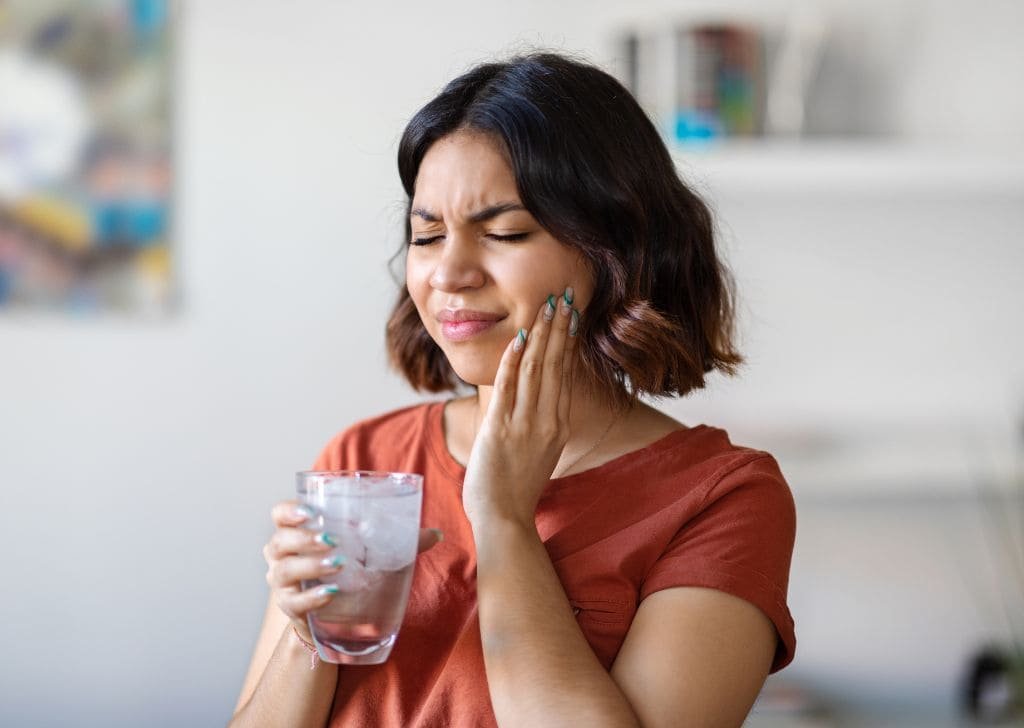 Woman having tooth pain when eating and drinking.