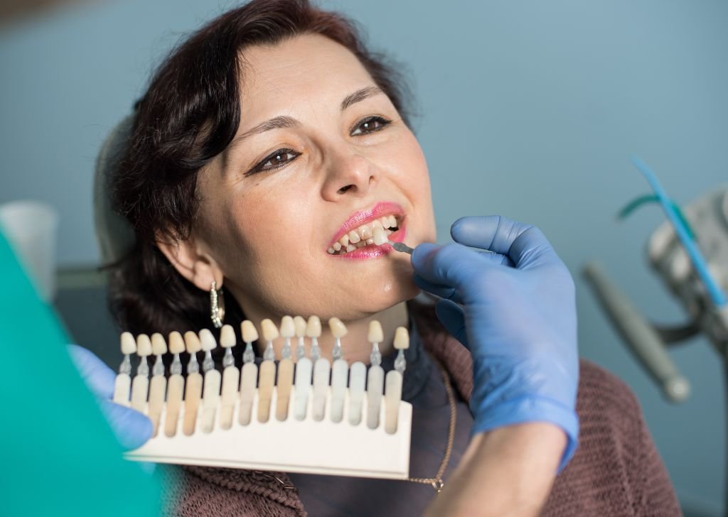 A woman discussing with her dentist which shade of white to go for during her teeth whitening.
